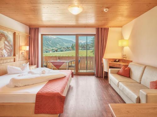 a hotel room with a bed and a couch at Hotel Magdalena im Zillertal - Urlaub mit Hund in Ried im Zillertal