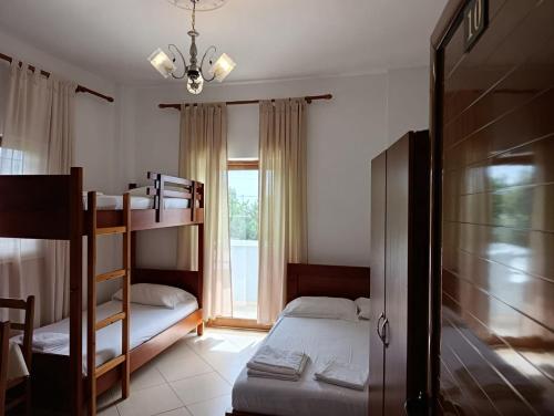 a bedroom with two bunk beds and a window at Aparthotel Fitimi in Borsh