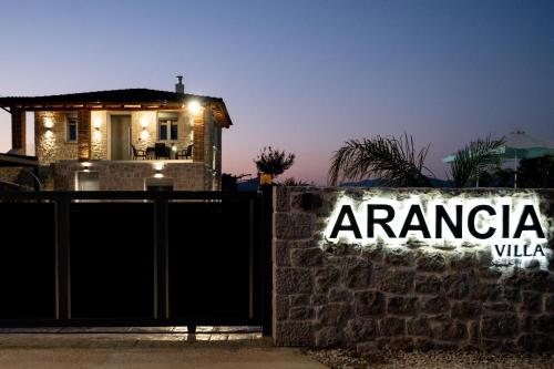 a house behind a fence with a sign that reads argaci villa at Villa Arancia in Argos