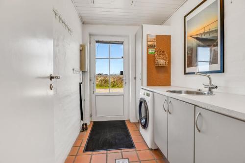 a bathroom with a sink and a washing machine at Feriehus 1145 in Ringkøbing