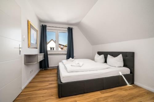 a bedroom with a bed with white sheets and a window at Feriwnohung Liv OG in Rechlin