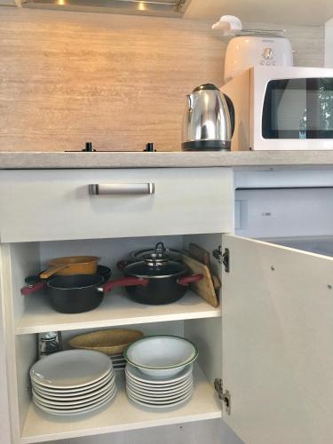 a kitchen with plates and pans and a microwave at Casa Vittoria in Nago-Torbole