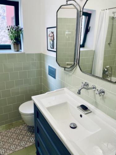 a bathroom with a sink and a toilet and a mirror at NEW - Casa Palamós - Charming historical home with patio, in the heart of the old town, 100m from beach in Palamós