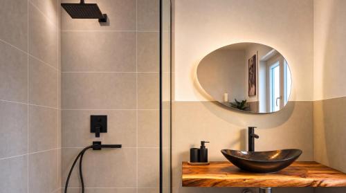 a bathroom with a sink and a mirror at Dreiländer Blick Apartment Premium in Lörrach