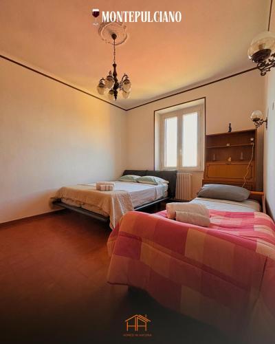 a bedroom with two beds and a chandelier at La Cameranense by Homes in Ancona in Camerano