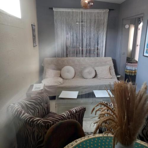 a living room with a couch and a table with chairs at Chalet vintage in Moralet