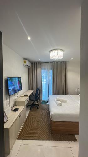 a bedroom with a bed and a desk and a tv at Luxury Studio Condo in Accra