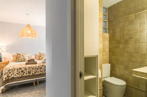 a bathroom with a bed and a toilet in a room at Los Altos in Almuñécar