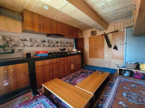 a kitchen with wooden cabinets and a wooden table at Gremuspa Homestay in Kyelang