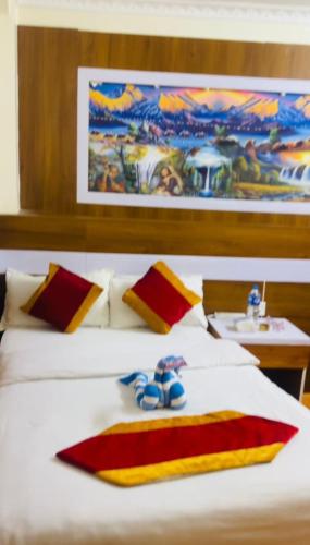 a bedroom with a white bed with red and yellow pillows at pokhara hotel Kathmandu pvt ltd in Kathmandu