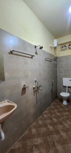 a bathroom with a sink and a toilet at Hotel Roy's in Shādipur