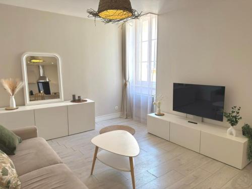a white living room with a tv and a couch at Le Cosy Caladois in Villefranche-sur-Saône