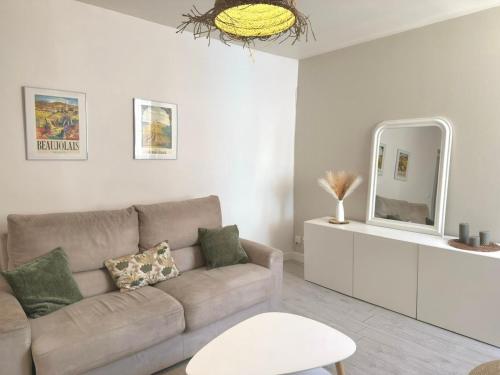 a living room with a couch and a mirror at Le Cosy Caladois in Villefranche-sur-Saône