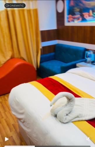 a room with two beds and a blue chair at pokhara hotel Kathmandu pvt ltd in Kathmandu