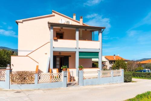 a white house with a fence in front of it at Passeggiata Alla Spiaggia in Campo nell'Elba