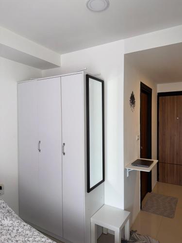 a bedroom with a white cabinet and a mirror at Sunset view apartment with a pool MAIKHAO Phuket in Ban Mai Salae