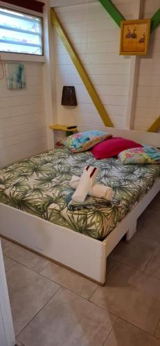 a bed with a stuffed animal laying on it at Méline in Baie-Mahault