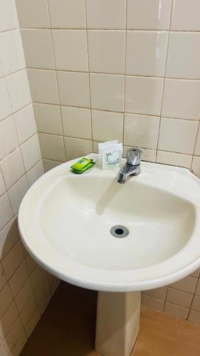 a white sink in a bathroom with a toothbrush at Central Suites - Hospedagem Super Econômica in Rio Verde