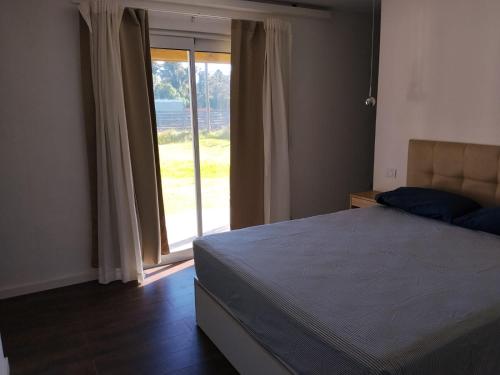 a bedroom with a bed and a sliding glass door at Villa Pi in Miramar