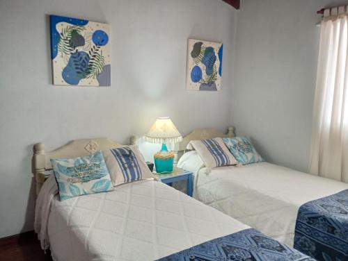 a bedroom with two beds and a lamp on a table at La Casa de Sol in Posadas
