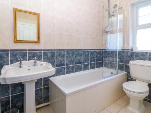 a bathroom with a sink and a toilet and a tub at Bryniau in Pwllheli