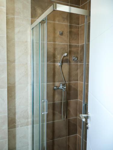 a shower in a bathroom with a glass door at Nada Apartman in Prijedor