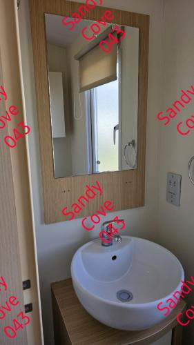 a bathroom with a white sink and a mirror at Sandy cove 043 in Barmouth