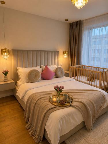 a bedroom with a large bed with a tray of flowers on it at A&K Apartament in Bacău