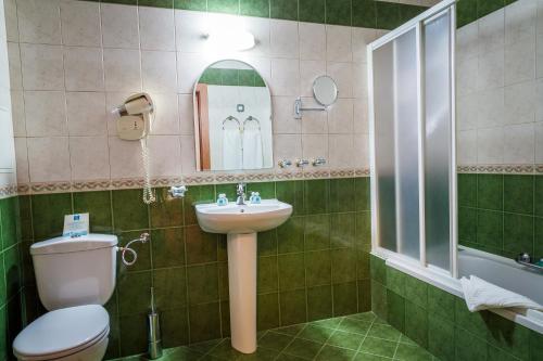 a bathroom with a toilet, sink and tub at Hotel Sevlievo Plaza in Sevlievo