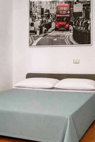 a bed with a picture of a red double decker bus at Appartamenti ABR Porto in Le Castella