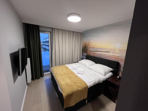 a bedroom with a bed with a view of the ocean at Golden Sun Apartment Grzybowo in Grzybowo