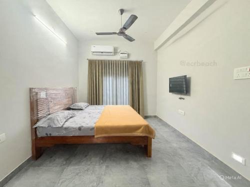 a bedroom with a bed and a ceiling fan at Sea shell in Covelong