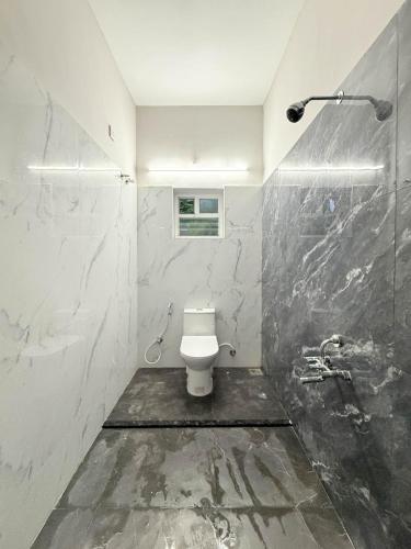 a bathroom with a toilet and a shower at Sea shell in Covelong