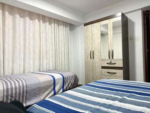 a bedroom with two beds and a cabinet with a mirror at Comodidad en un solo lugar in Lima