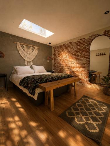 a bedroom with a bed and a brick wall at Cabañas Boutiques TinyChillHouse in Mineral del Chico