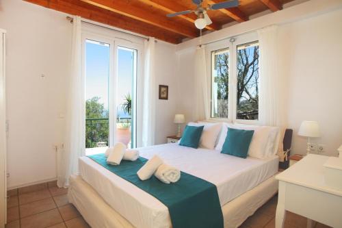 a bedroom with a large bed with a large window at Villa Panorama in Kalamitsi