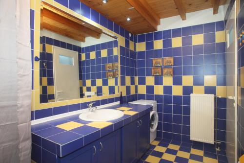 a blue and yellow bathroom with a sink and a toilet at Villa Panorama in Kalamitsi