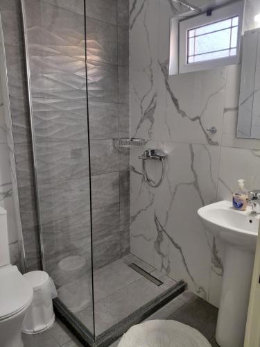 a bathroom with a shower and a sink at Neptune Resort in Kavos