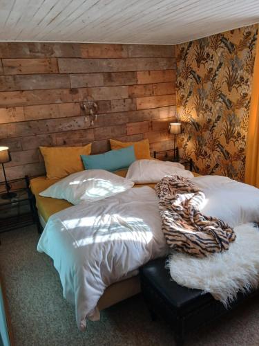 a bedroom with two beds and a wooden wall at Sabershausen Landhof Sonne in Sabershausen