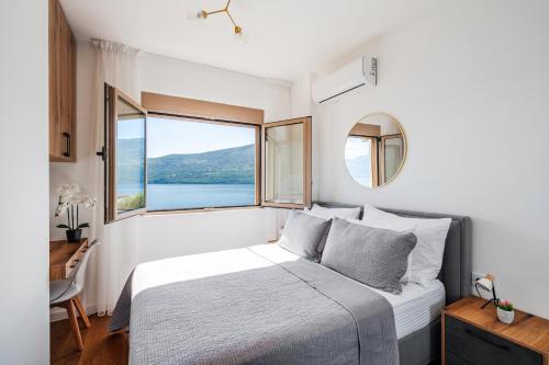 a bedroom with a large bed and a large window at Anna Luxury BELLA VISTA in Baošići
