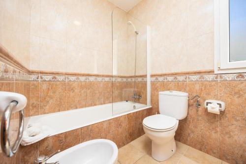 a bathroom with a toilet and a tub and a sink at Villa Elena Dorada in Port d'Addaia