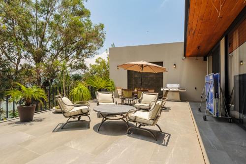 a patio with a table and chairs and an umbrella at Villa del Carmen in Colorines