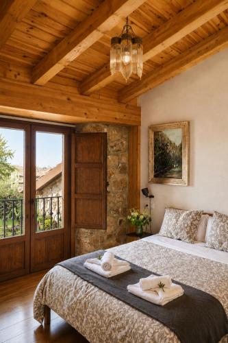 a bedroom with a large bed with towels on it at Casa Luenga in Vinuesa