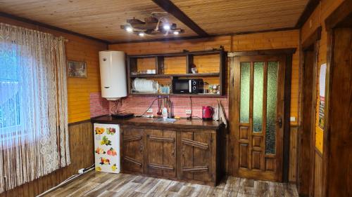 a kitchen with wooden cabinets and a white refrigerator at Котедж Віадук in Vorokhta