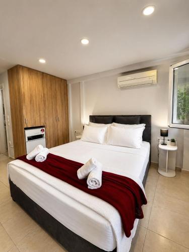 a bedroom with a large bed with towels on it at Studio next to the Beach in Vouliagmeni