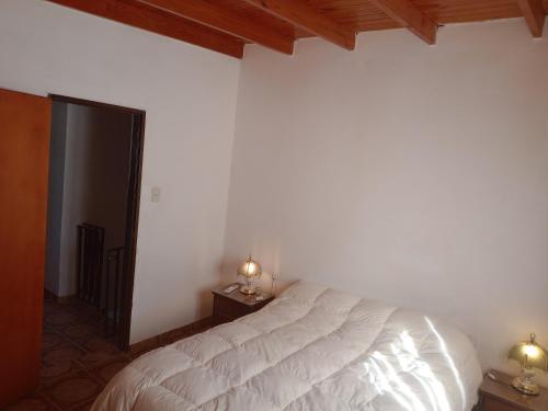 a bedroom with a white bed and two night stands at Duplex Hermosinda Hospedaje in Chilecito