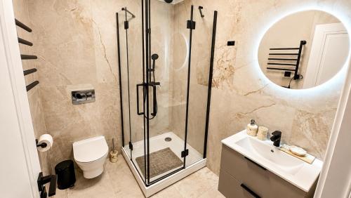 a bathroom with a shower and a toilet and a sink at Greystone Suites & Apartments in Riga