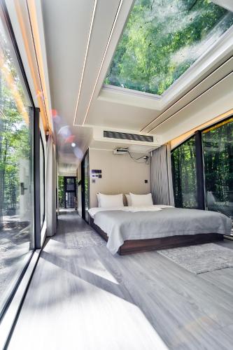 a bedroom with a large bed and large windows at Rado Hotel Spa in Khmilnyk