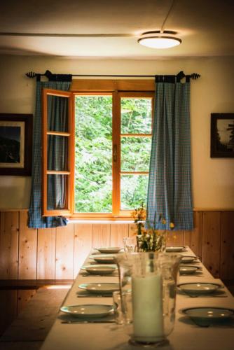 a dining room with a long table and a window at Leislinghütte in Bad Goisern
