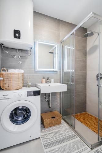 a bathroom with a washing machine and a sink at Anna Luxury BELLA VISTA in Baošići